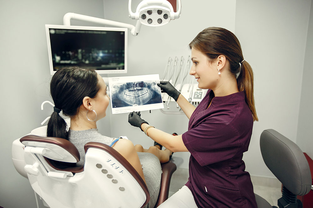 Dental hygienist showing patient x-rays